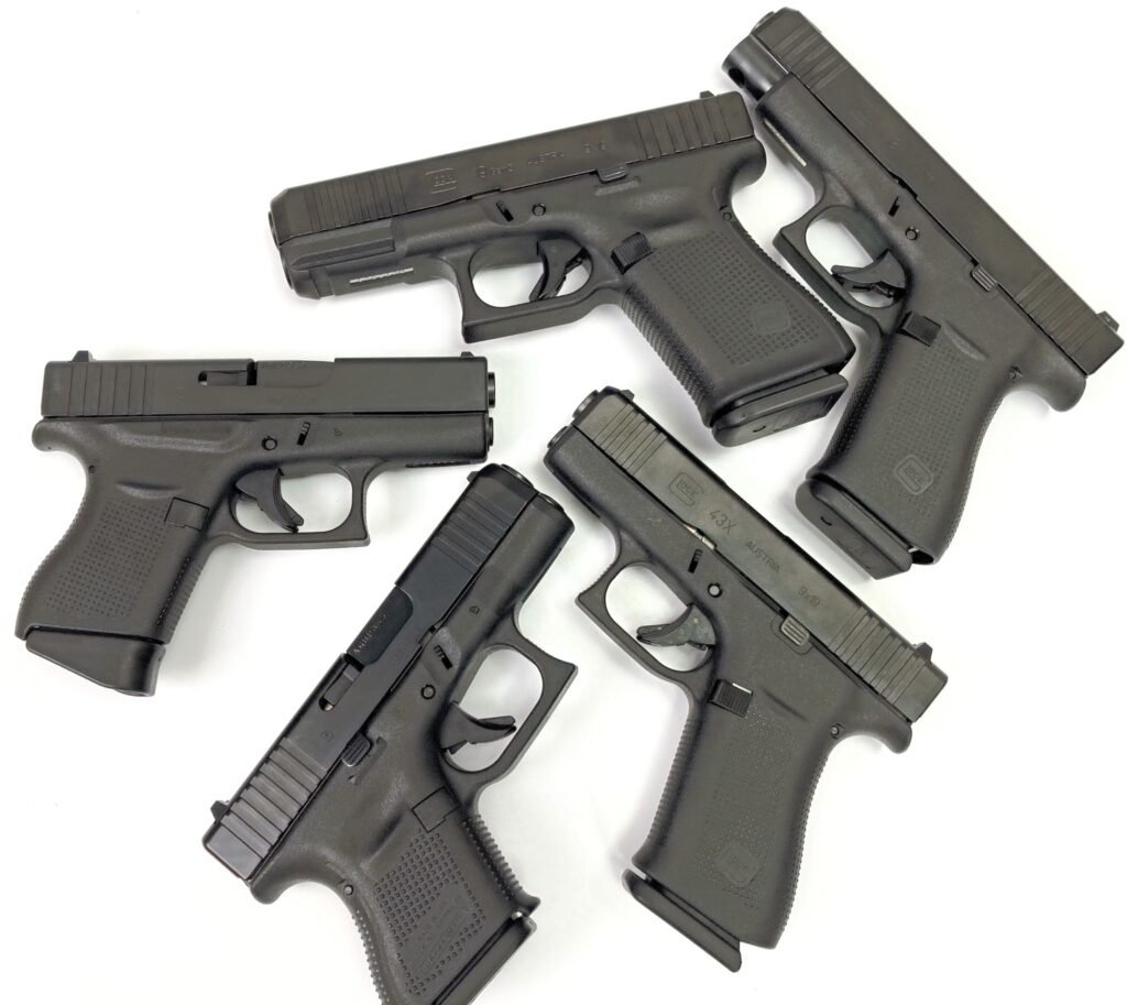 assorted glock handguns on a table.